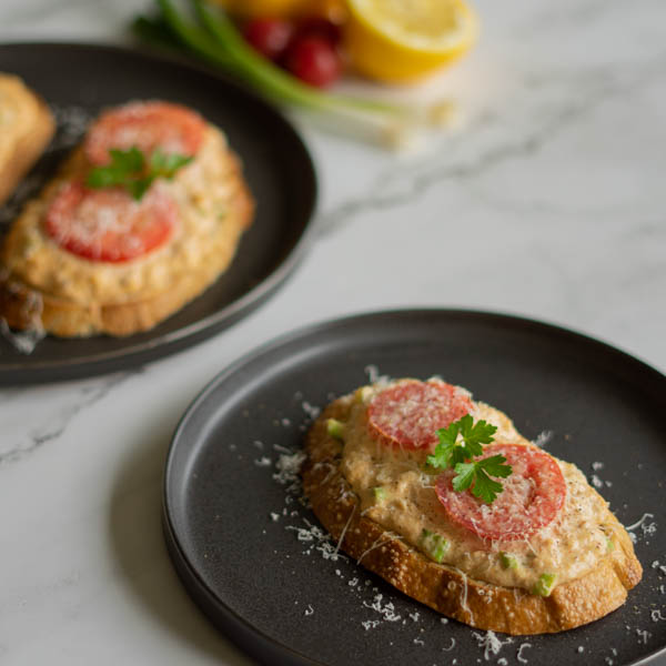 Sourdough topped with creamy crab, sliced tomatoes, and paremesan