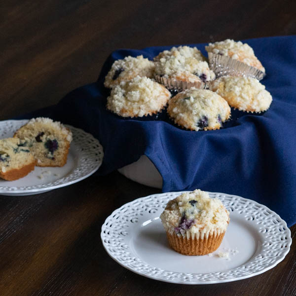 Banana Blueberry Muffins on white plates with bowl of muffins