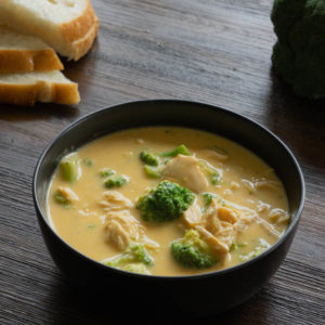 Broccoli Cheese Soup in a black bowl with bread