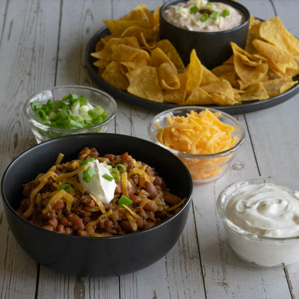 Chili with toppings and chips and dip