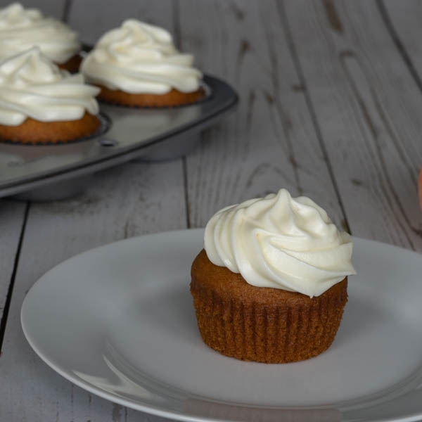 Pumpkin Cupcake with Cream Cheese Frosting on a white plate