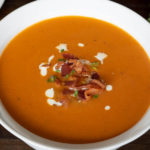 Tomato Bisque topped with bacon, thyme, and cream