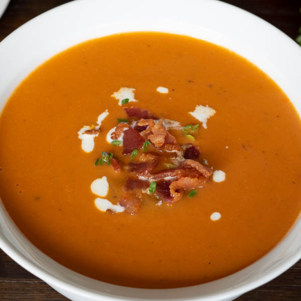 Tomato Bisque topped with bacon, thyme, and cream