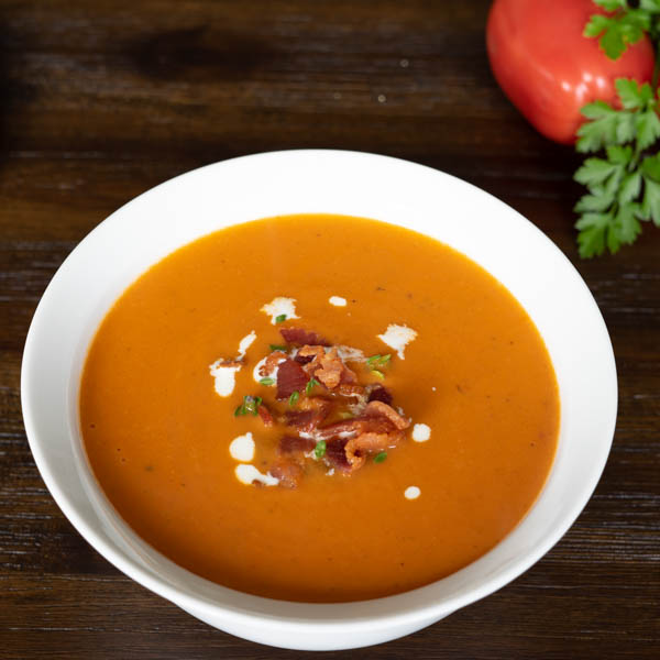 Tomato Bisque topped with bacon, thyme, and cream